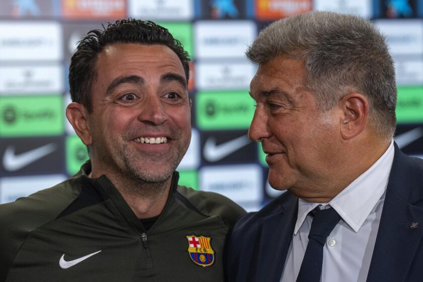 El técnico del Barcelona Xavi Hernández sonríe al lado del presidente Joan Laporta durante una rueda de prensa, el jueves 25 de abril de 2024. (AP Foto/Emilio Morenatti)