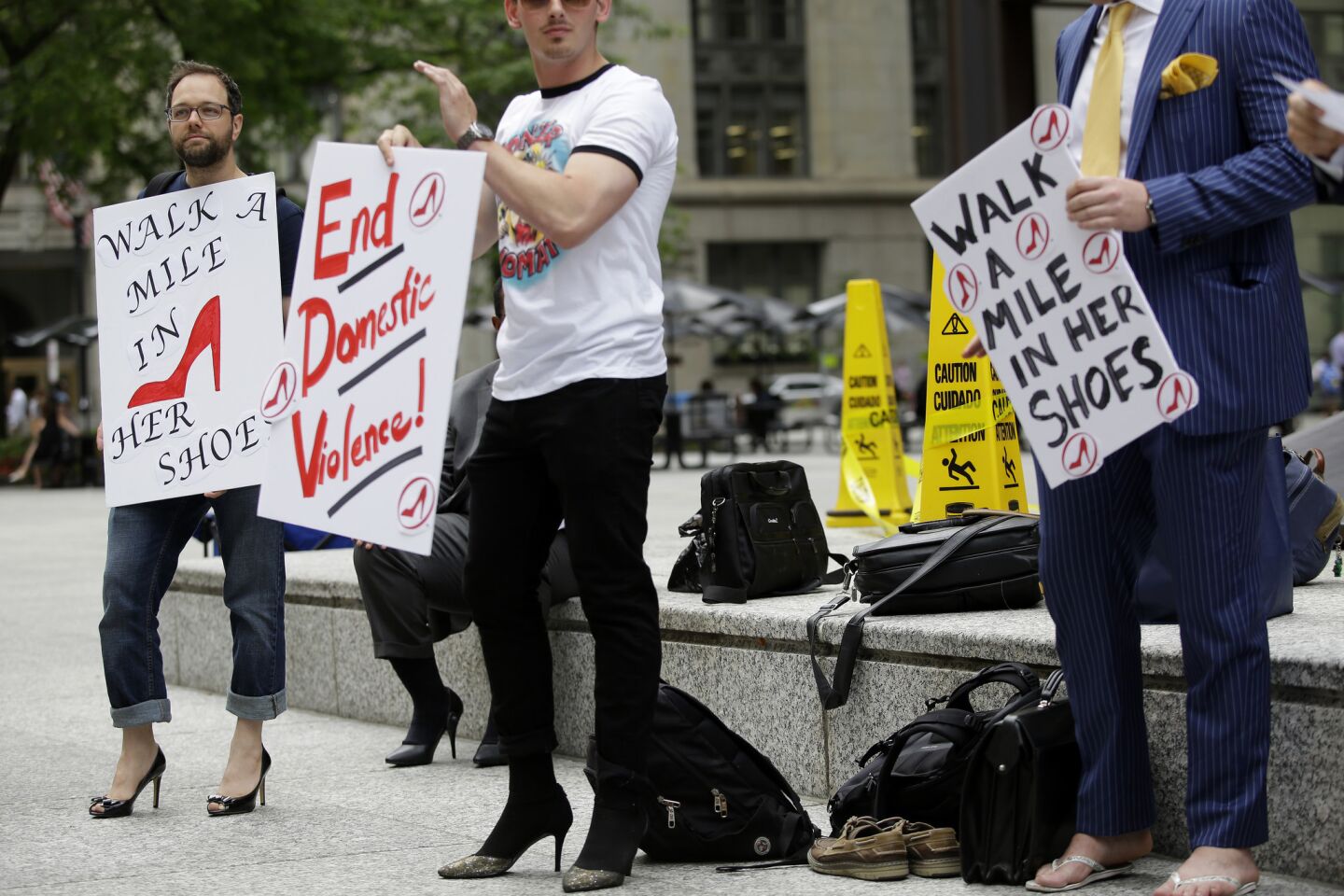 Male attorneys strapped on pairs of high heels to shed some light on violence against women during a Walk a Mile in Her Shoes event in Chicago, Illinois on June 14, 2018. Just under a dozen men from the Chicago Bar Association's Young Lawyers Section participated in the one-mile march from Daley Plaza to the Hyatt Hotel.