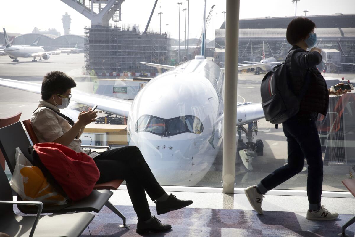 Travelers wear face masks as they wait for their flight at Hong Kong International Airport on Jan. 21.