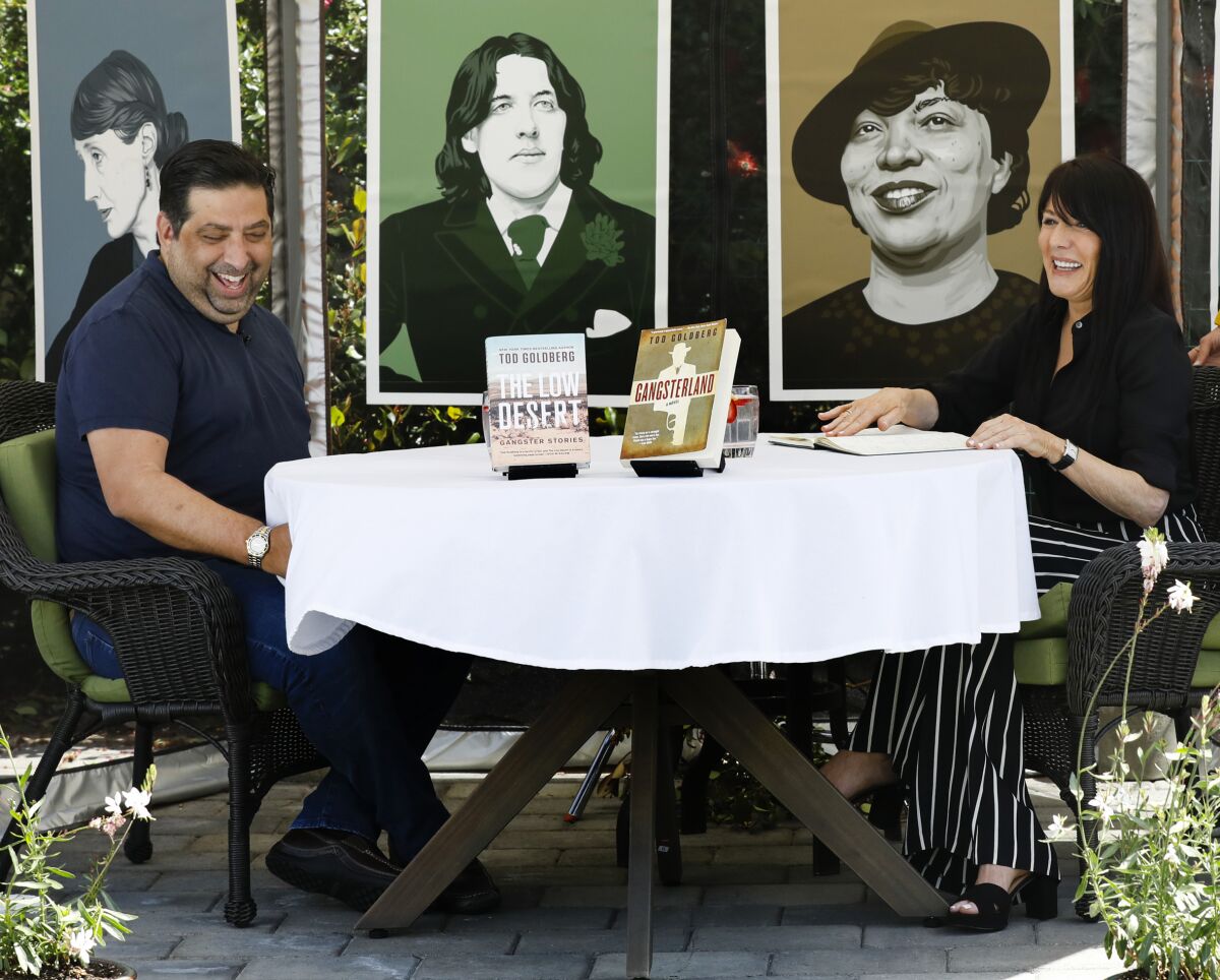 Author Tod Goldberg, left, being interviewed by novelist Ona Russell in her backyard tent in Solana Beach on May 29.