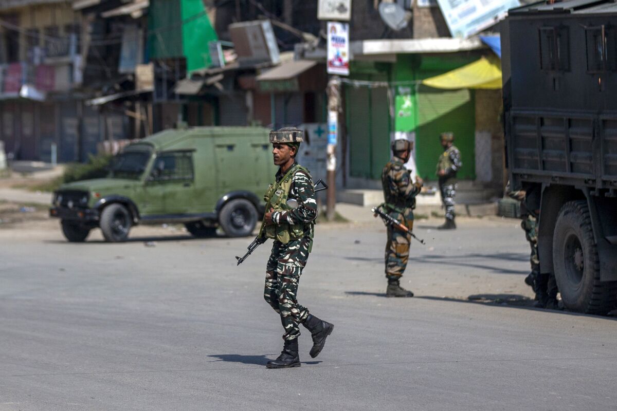 Indian paramilitary soldiers stand guard on a road leading towards the site of a gunfight in Pampore, south of Srinagar, Indian controlled Kashmir, Saturday, Oct. 16, 2021. Indian government forces killed five rebels in last 24-hours in disputed Kashmir on Saturday, officials said, as violence increased in recent weeks.(AP Photo/Dar Yasin)
