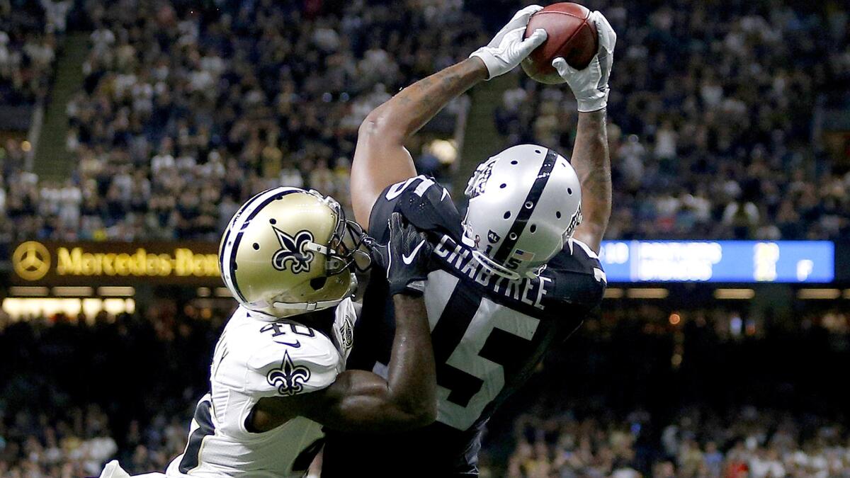 Raiders receiver Michael Crabtree catches the winning two-point conversion pass over Saints defensive back Delvin Breaux on Sunday.
