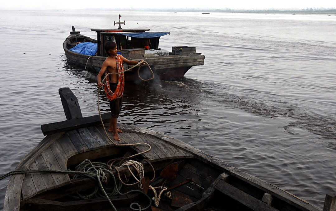 A deckhand coils the mooring lines of a riverboat