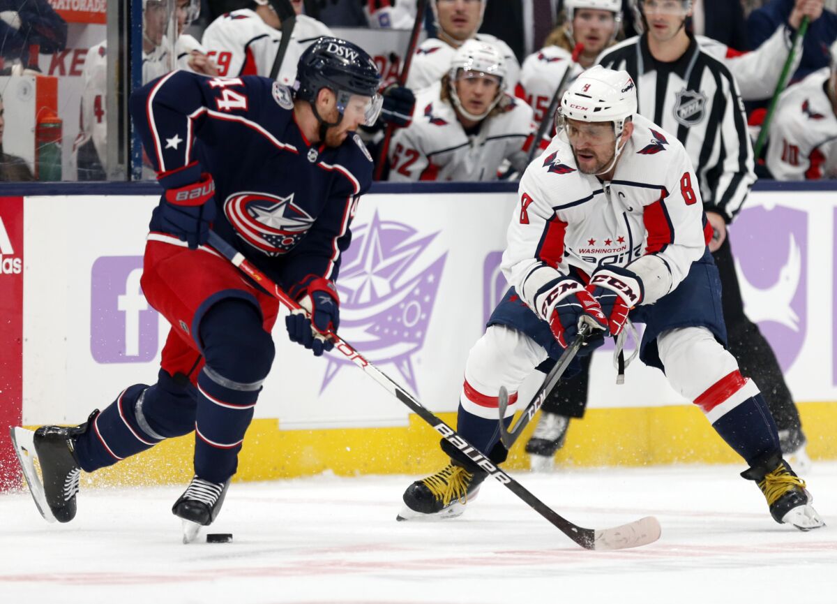 Washington Capitals forward Alex Ovechkin, right, chases the puck in front of Columbus Blue Jackets defenseman Vladislav Gavrikov during the first period of an NHL hockey game in Columbus, Ohio, Friday, Nov. 12, 2021. (AP Photo/Paul Vernon)