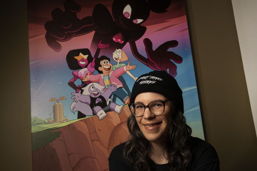 BURBANK, CA-MARCH 9, 2020: Rebecca Sugar, creator/showrunner of "Steven Universe" and "Steven Universe Future" is photographed next to key art from Steven Universe: The Movie, on display at Cartoon Network Studios in Burbank. (Mel Melcon/Los Angeles Times)