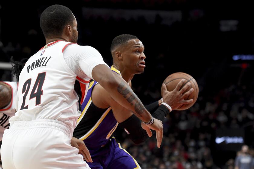 Los Angeles Lakers guard Russell Westbrook, right, drives to the basket on Portland Trail Blazers forward Norman Powell, left, during the first half of an NBA basketball game in Portland, Ore., Saturday, Nov. 6, 2021. (AP Photo/Steve Dykes)