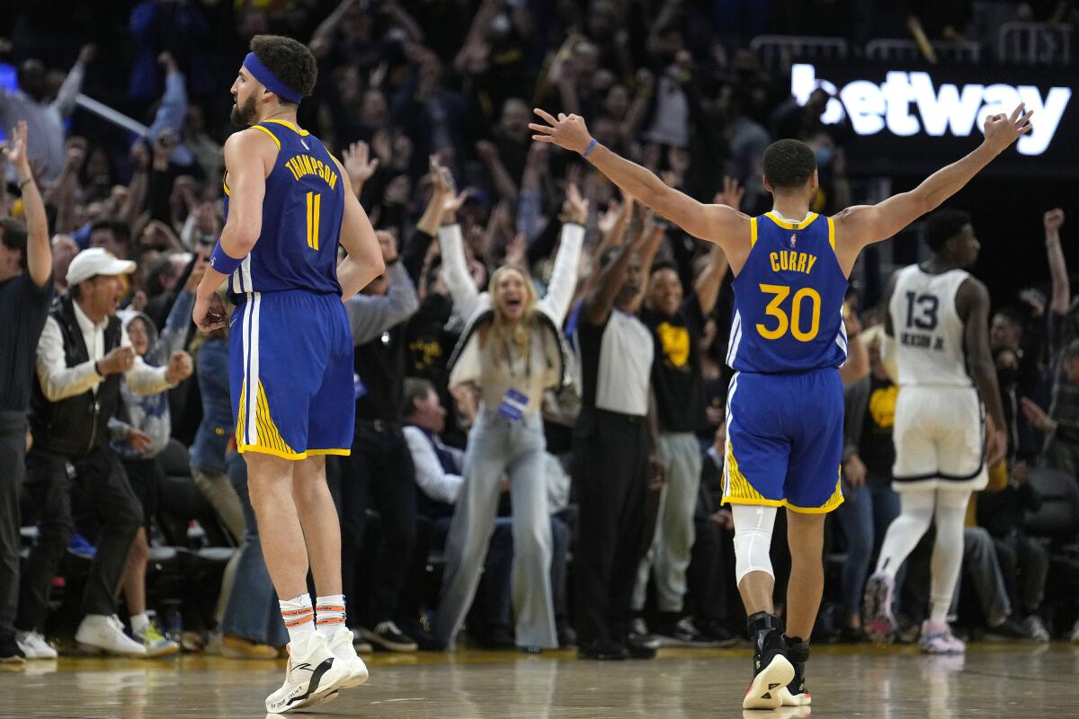 Golden State Warriors guard Stephen Curry (30) celebrates a 3-pointer by Klay Thompson, left, against the Memphis Grizzlies during the second half of Game 6 of an NBA basketball Western Conference playoff semifinal in San Francisco, Friday, May 13, 2022. The Warriors won 110-96 and advanced to the conference finals. (AP Photo/Tony Avelar)