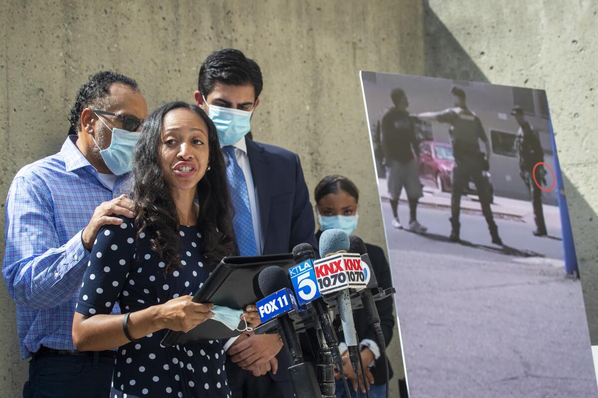 Latoya Reinhold, widow of Kurt Reinhold, reads a prepared statement at a news conference in Santa Ana.