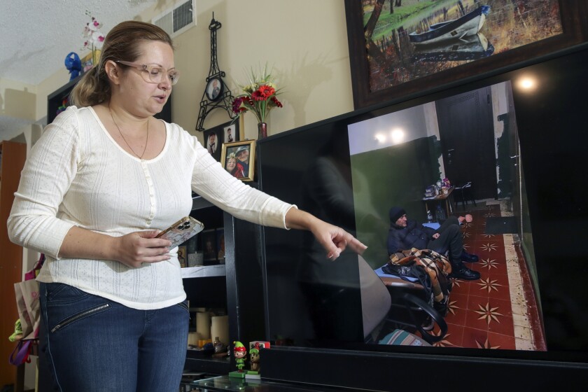 Woman pointing to her father's picture on TV