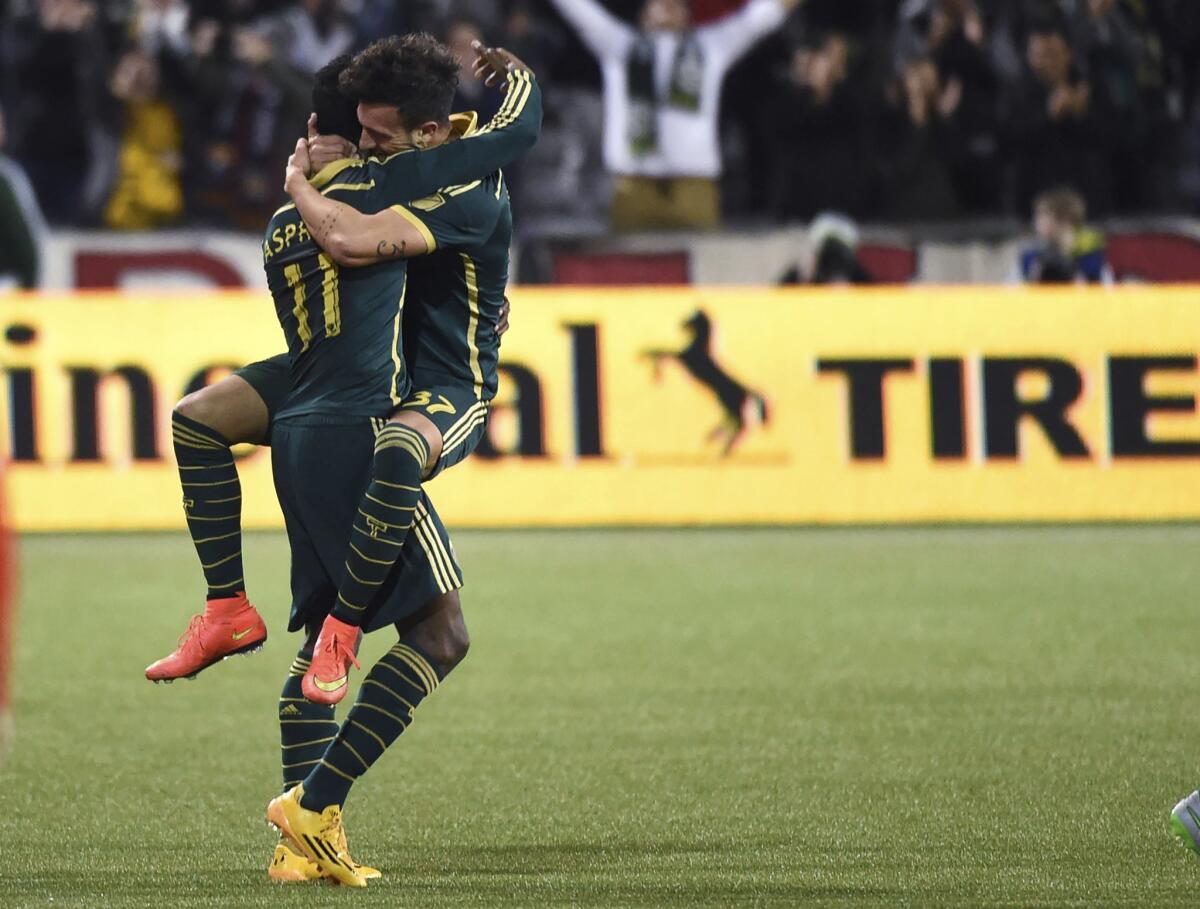 Portland Timbers midfielder Maximiliano Urruti (37) celebrates with midfielder/forward Dairon Asprilla (11) after Urruti scored a goal during overtime in an MLS playoff soccer match against Sporting Kansas City in Portland, Ore., on Thursday, Oct. 29, 2015. The Timbers won 7-6 in the shootout after a 2-2 draw. (AP Photo/Steve Dykes)