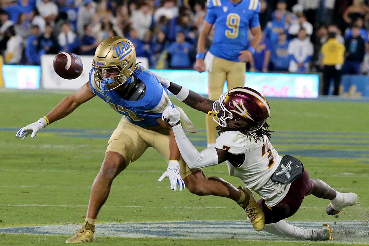 UCLA wide receiver Logan Loya can't hang on to a pass as Arizona State defensive back Shamari Simmons pulls him down.