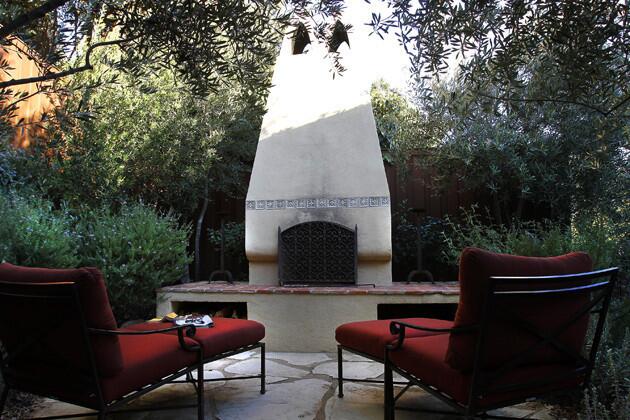 For continuity, designer Daigre borrowed created the outdoor fireplace using details from inside the house: hexagonal terra cotta tiles from the original living room hearth and glazed ceramic tiles from the remodeled kitchen backsplash. Openings below the fireplace provide storage for firewood.