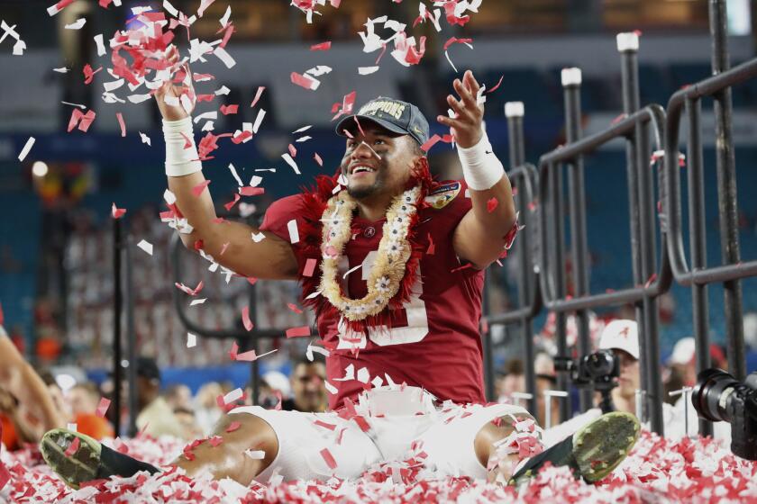 FILE - In this Dec. 30, 2018, file photo, Alabama quarterback Tua Tagovailoa throws confetti in the air after winning the Orange Bowl NCAA college football game against Oklahoma, in Miami Gardens, Fla. Tagovailoa had to settle for second place in the Heisman Trophy balloting, but he delivered arguably the best bowl performance of any player in the country. Tagovailoa outdueled Heisman Trophy winner Kyler Murray of Oklahoma in the Sugar Bowl to earn his spot as the quarterback of our all-bowl team. (AP Photo/Wilfredo Lee, File)