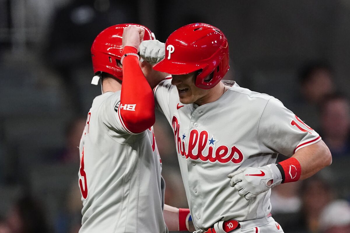 Philadelphia Phillies' J.T. Realmuto, right, celebrates with Bryce Harper after hitting a two-run home run in the eighth inning of a baseball game against the Atlanta Braves, Friday, May 7, 2021, in Atlanta. (AP Photo/John Bazemore)