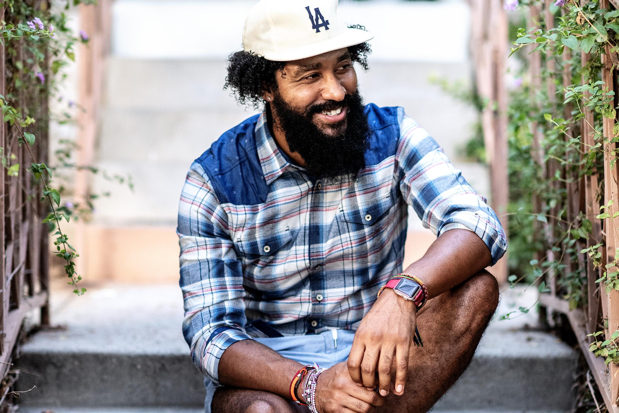 A man sits on concrete steps, smiling.