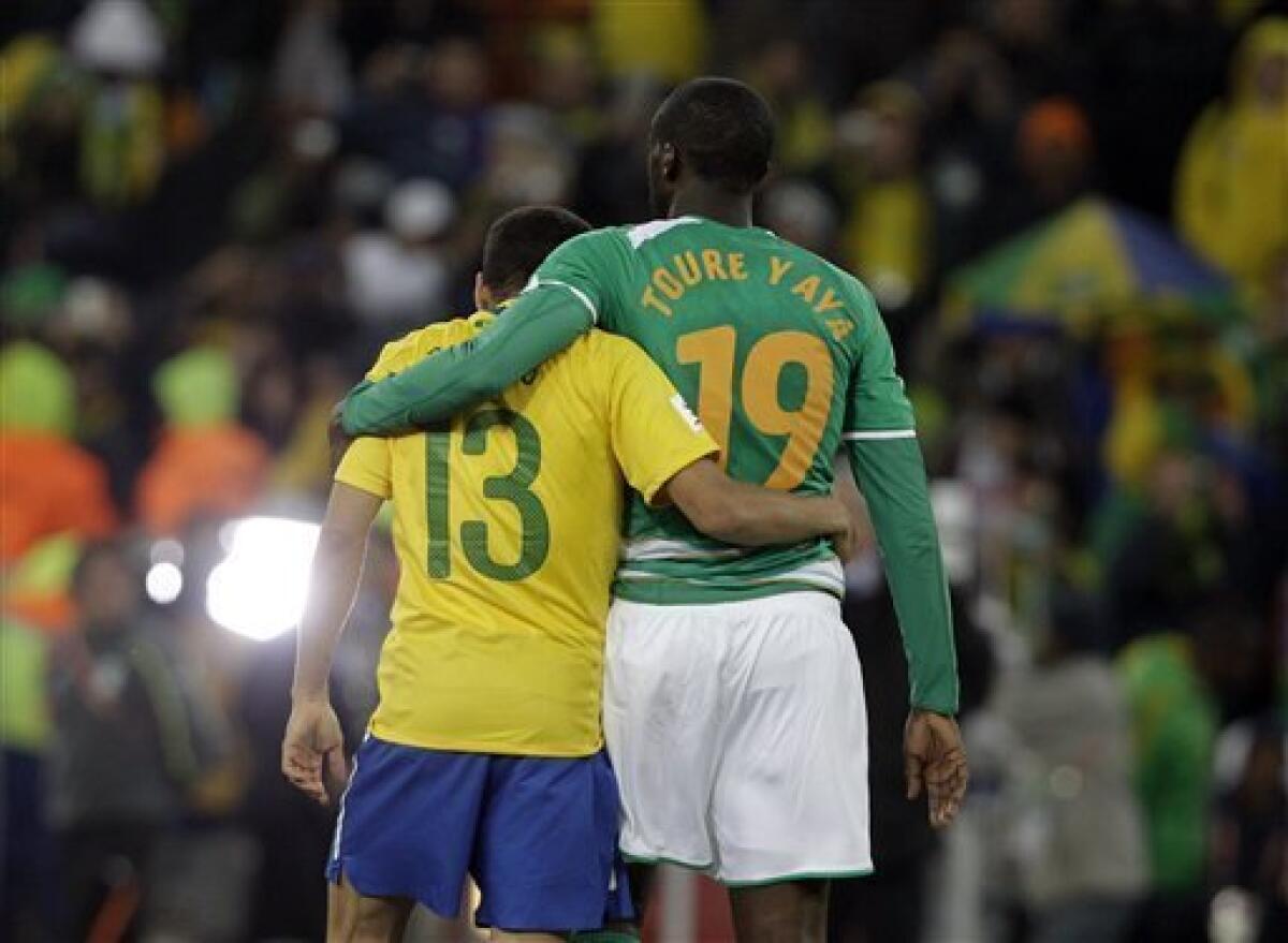 Brazil's Daniel Alves, left, and Ivory Coast's Yaya Toure embrace as they leave the pitch after the World Cup group G soccer match between Brazil and Ivory Coast at Soccer City in Johannesburg, South Africa, Sunday, June 20, 2010. (AP Photo/Frank Augstein)