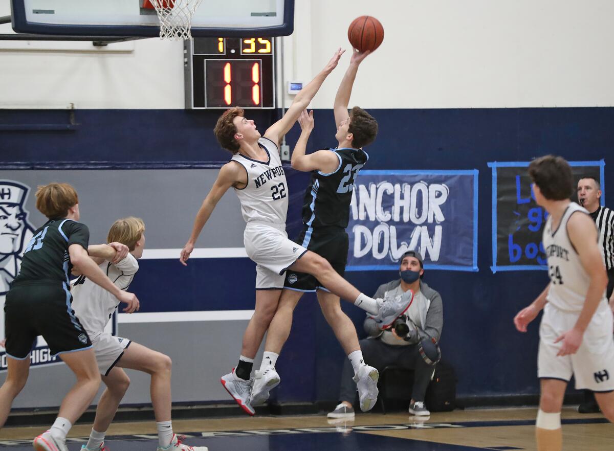 Newport Harbor's Riggs Guy (22) defends against Corona del Mar's Dylan Rogers during the Battle of the Bay game on Friday.