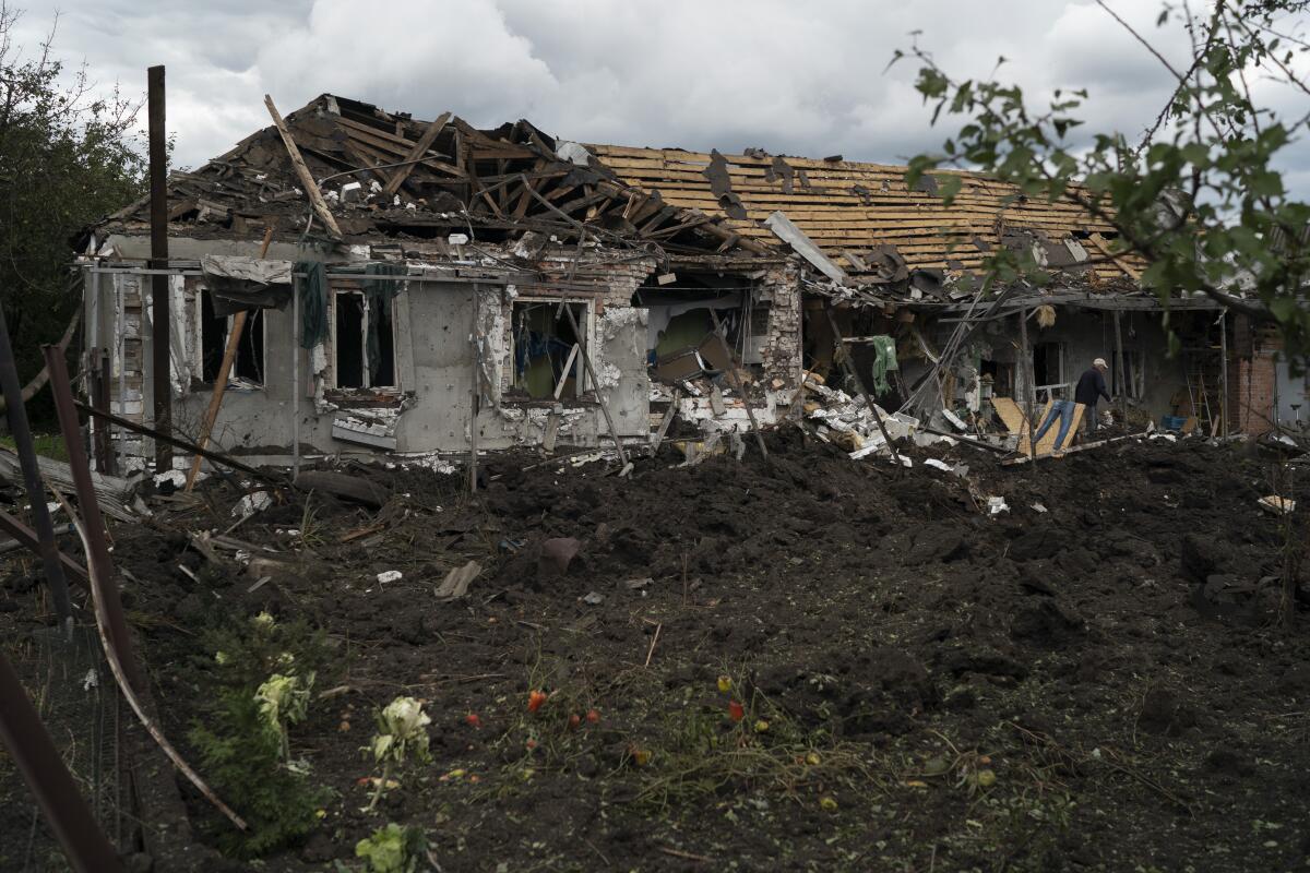 Un hombre camina sobre los escombros de una casa después de un ataque ruso en Sloviansk, 