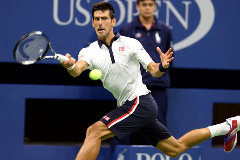 Novak Djokovic hits a return to Roberto Bautista Agut during their U.S. Open match on Sunday.