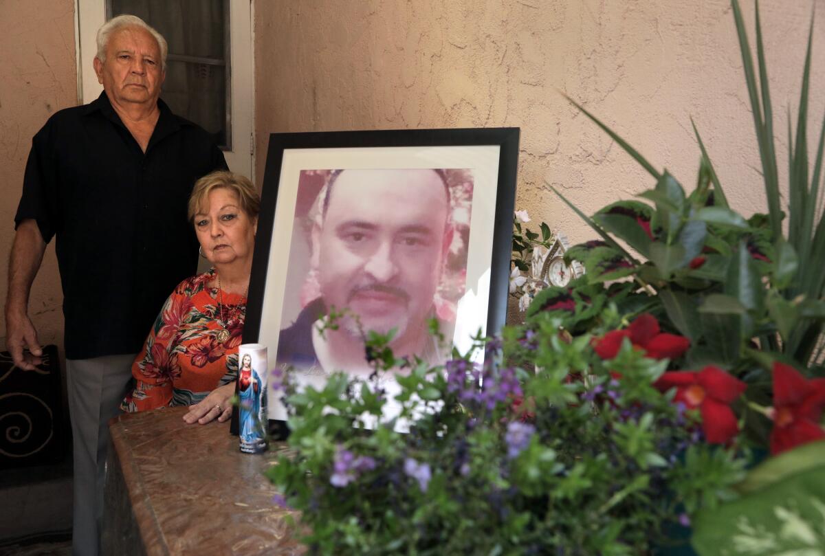 Juan and Blanca Briceno with a shrine for their son Eric Briceno 