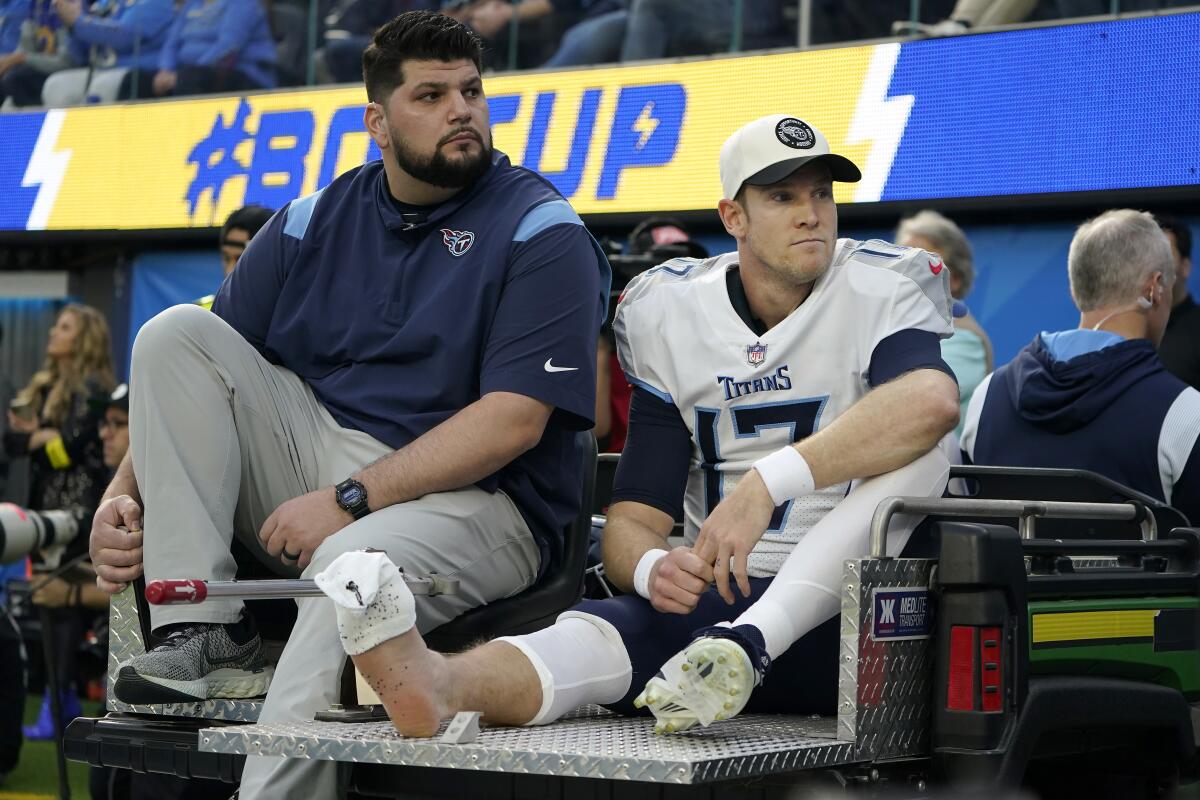 Tennessee Titans quarterback Ryan Tannehill, right, is carted off the field during the first half.