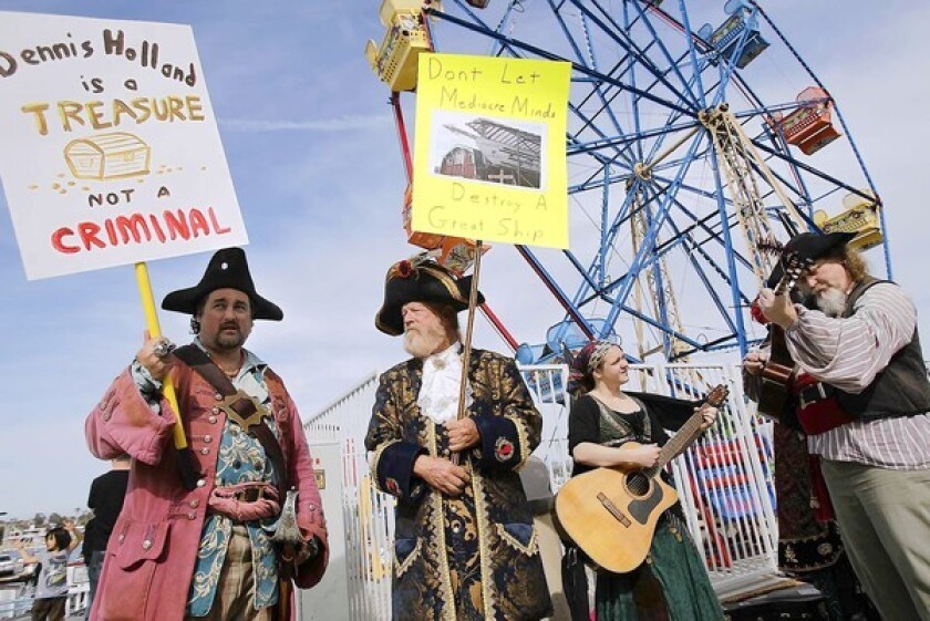 Dennis Holland supporters, from left, Mitch Toles of Palmdale, George Pepper of Joshua Tree, Megan Doyle of Riverside, and Brant Johnson of Covina, protest by the Balboa Island Ferry on Saturday.