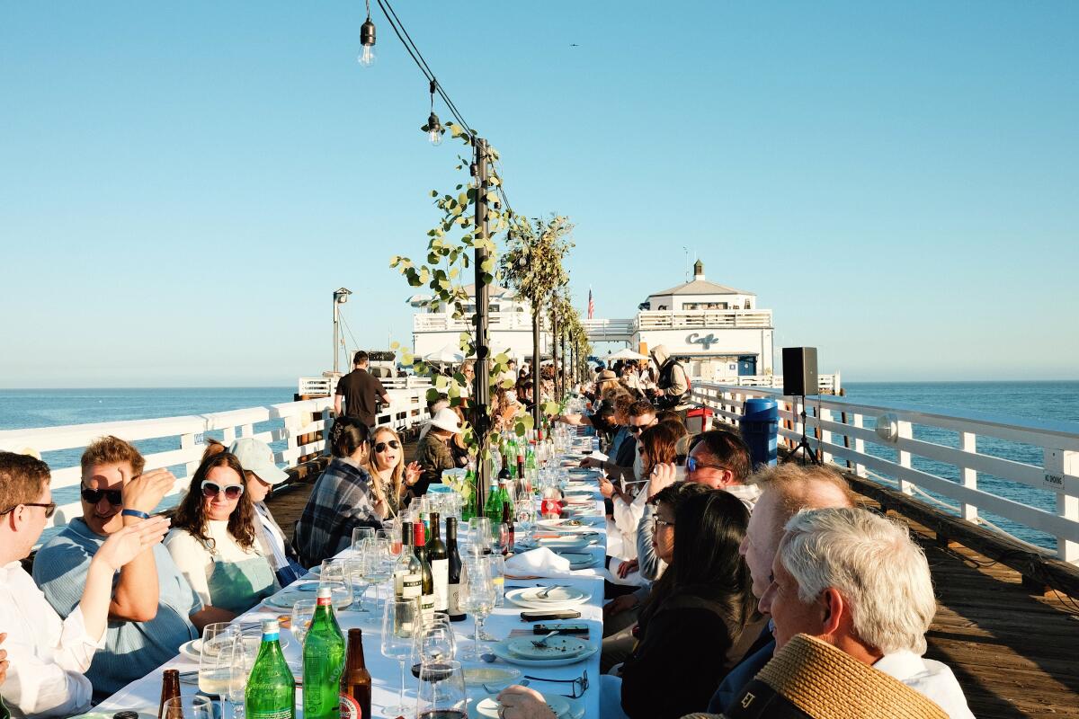 A table of guests on the Malibu Pier for the L.A. Times Great Australian Bite event with visiting and local Australian chefs.