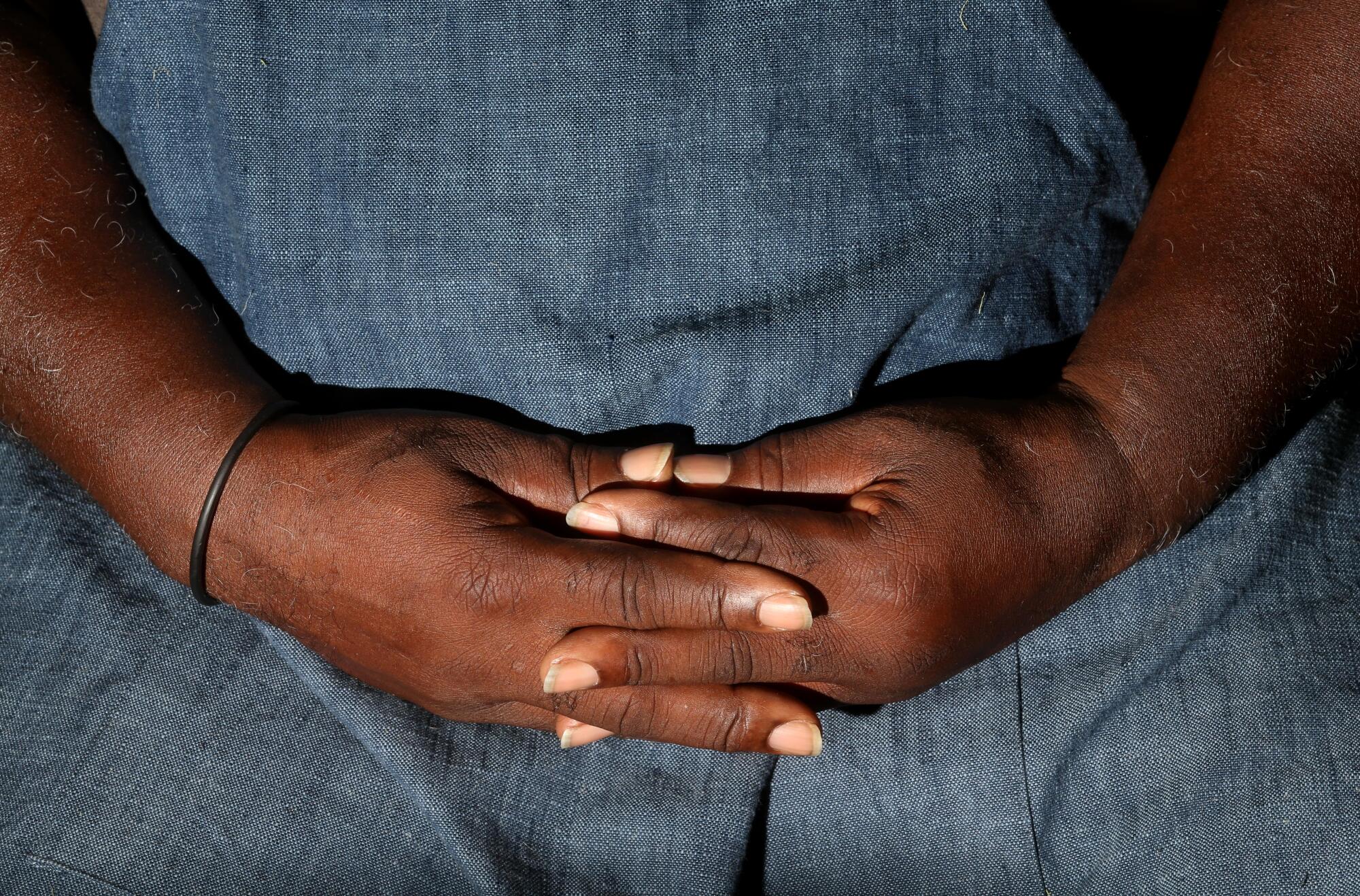 With folded hands, Gary Tyler spends a moment of reflection in his studio