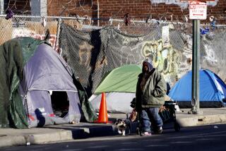 A homeless man walks with his dog along a street in the Skid Row section on Los Angeles on Thursday, Jan. 11, 2024. (AP Photo/Richard Vogel)