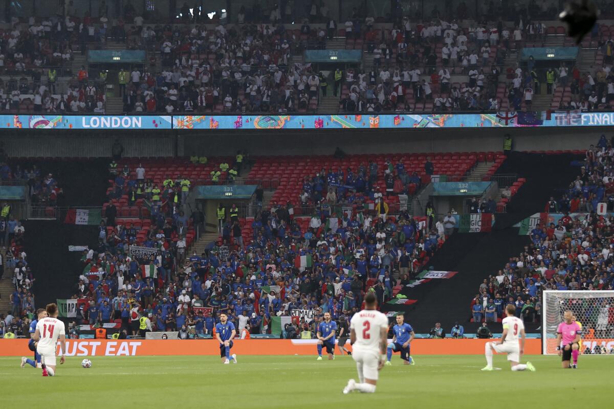 The players take a knee before the Euro 2020 soccer championship final match between England and Italy at Wembley stadium in London, Sunday, July 11, 2021. (Carl Recine/Pool Photo via AP)