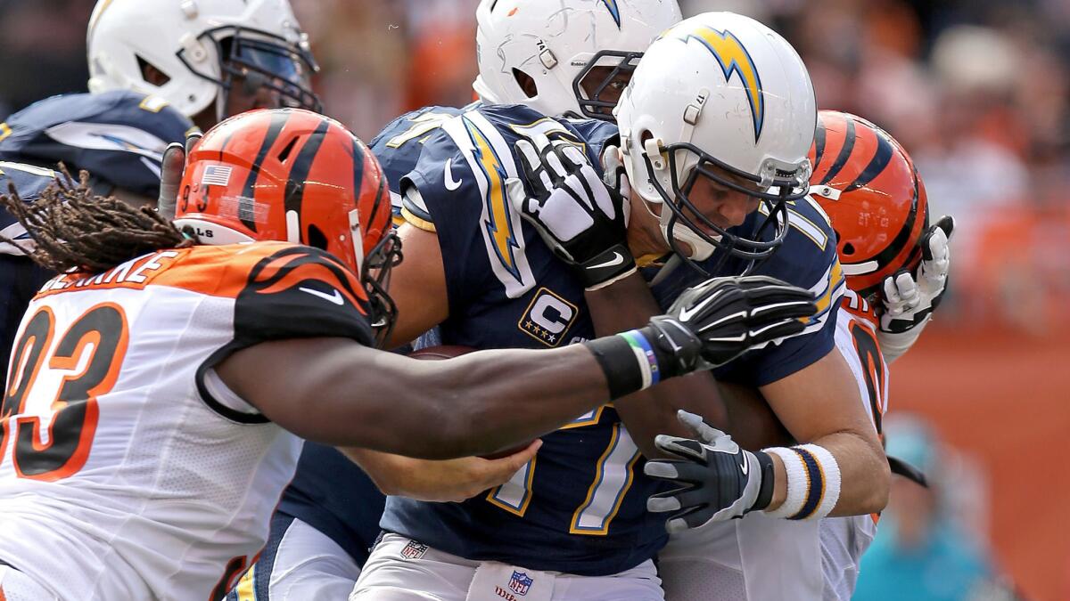Chargers quarterback Philip Rivers is sacked by Bengals defensive linemen Will Clarke (93) and Geno Atkins in the second half Sunday in Cincinnati.