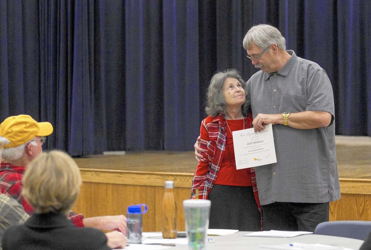 Bill Nelson with Fresh Beginnings Ministries gives a Life Support Mentor certificate to Judy Haskell on Monday, November 9 at the Costa Mesa Neighborhood Center. The graduation ceremony was held for people who completed 30 hours of educational training in the area of mentorship for the homeless.