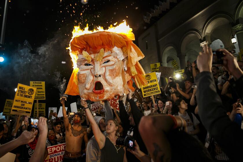 Protesters burn an effigy of Donald Trump outside Los Angeles City Hall on Wednesday.