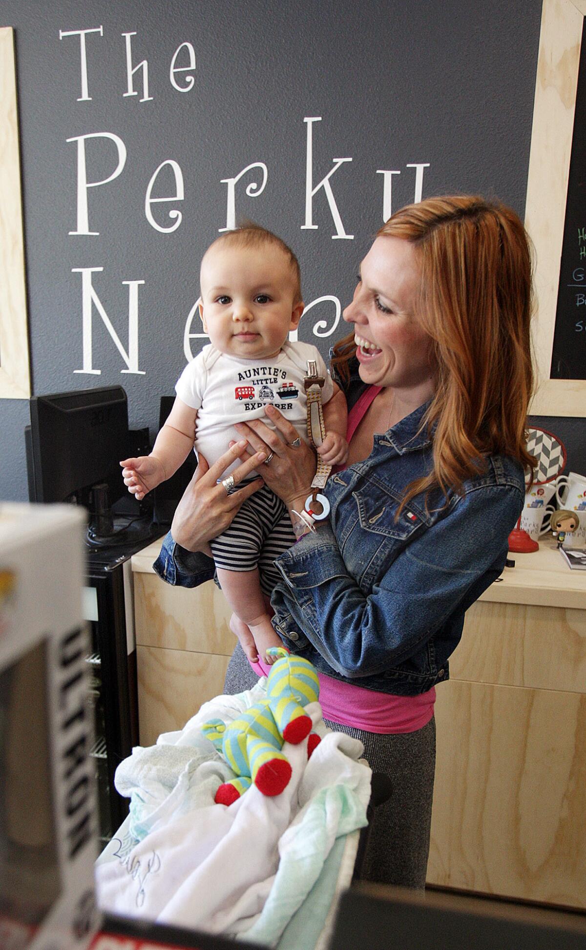 Store owner Tiffany Melius with her 8-month-old son Jack at The Perky Nerd, a 5-day old comic book and coffee store in Burbank on Thursday, April 28, 2016.