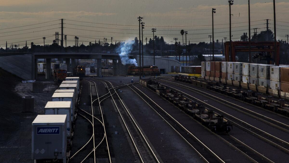 Smoke billows from a locomotive at a rail yard in San Bernardino. A proposal under consideration by the South Coast Air Quality Management District would pursue rules for rail yards, warehouses and major construction projects across the region.