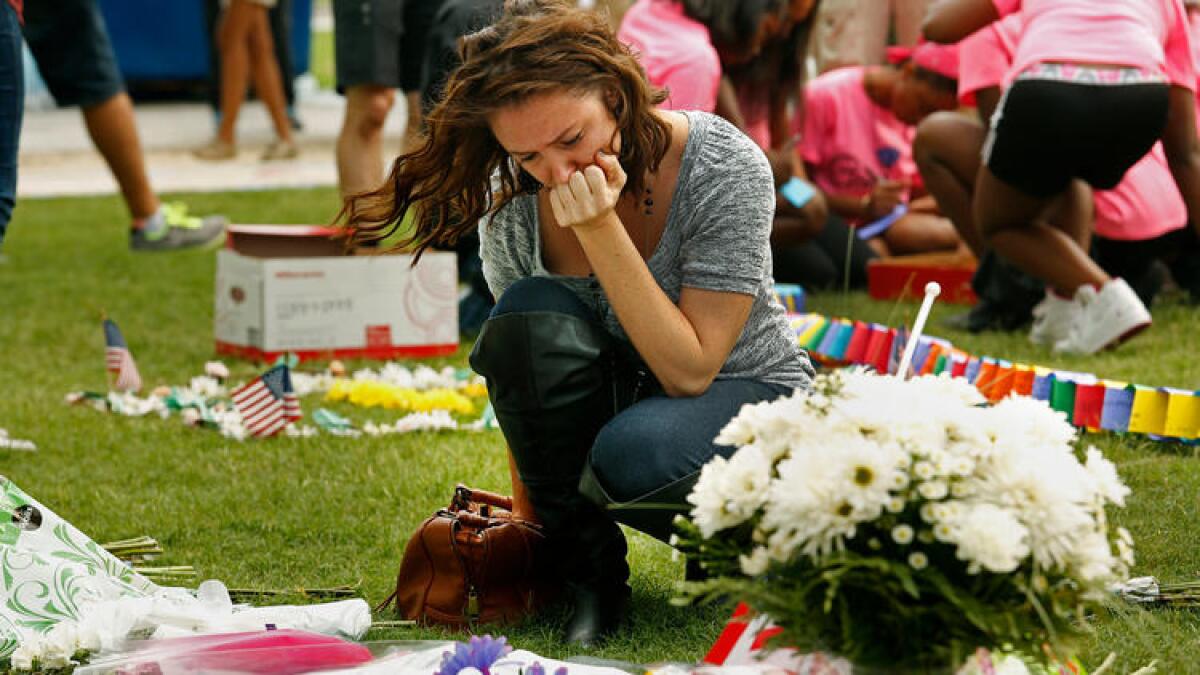 Danielle Irigoyen brings flowers to a memorial for the victims of the Pulse nightclub shooting in Orlando, Fla.