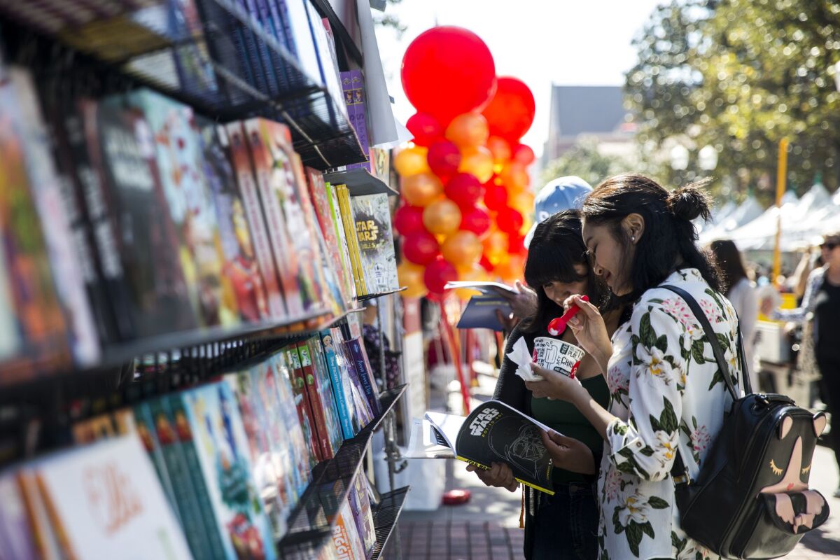 Elisa Sifuentes, 16, and Kaitlyn Bin, 16, browse at the L.A. Times Festival of Books on the USC campus.