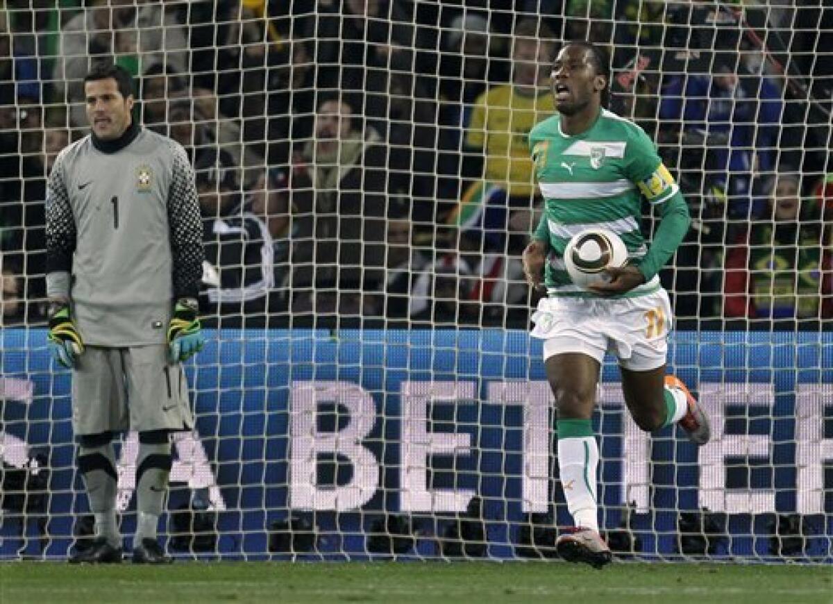 Ivory Coast's Didier Drogba, right, takes the ball out of the net after scoring a goal against Brazil goalkeeper Julio Cesar, left, during the World Cup group G soccer match between Brazil and Ivory Coast at Soccer City in Johannesburg, South Africa, Sunday, June 20, 2010. (AP Photo/Matt Dunham)