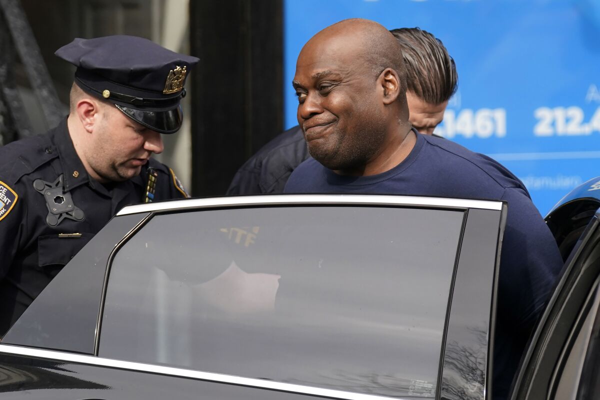 New York City Police, left, and law enforcement officials lead subway shooting suspect Frank R. James, 62, right, into a car and away from a police station, in New York, Wednesday, April 13, 2022. The man accused of shooting multiple people on a Brooklyn subway train was arrested Wednesday and charged with a federal terrorism offense. (AP Photo/Seth Wenig)