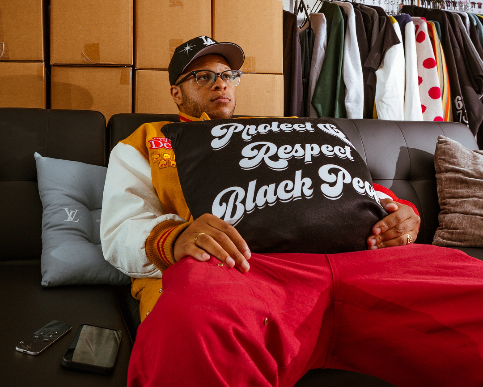 A person leans back on a couch, holding a pillow that says "Protect and respect Black people."