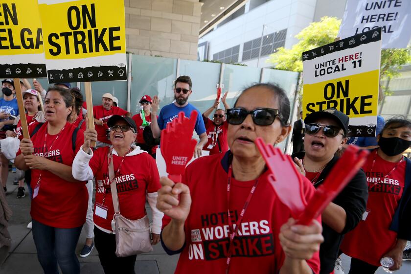 Los Angeles, CA - Striking members of the Unite Here Local 11 hotel workers union make noise on the picket line outside the JW Marriott and Ritz-Carlton hotels in downtown Los Angeles on Monday, July 3, 2023. The strike affects roughly 15,000 cooks, room attendants, dishwashers, servers, bellmen and front-desk agents at hotels in Los Angeles and Orange counties, July 03: in Los Angeles on Monday, July 3, 2023 in Los Angeles, CA. (Luis Sinco / Los Angeles Times)