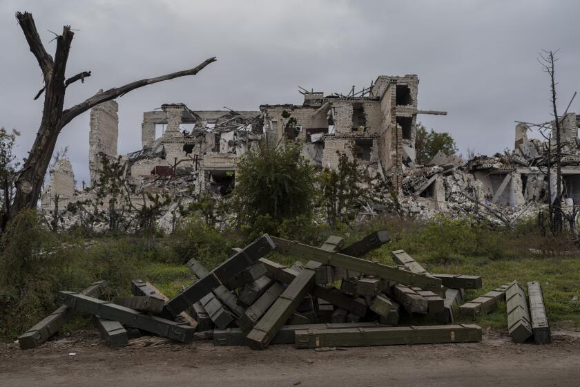 Ammunition boxes lay outside a destroyed school on the outskirts of a recently liberated village outskirts of Kherson, in southern Ukraine, Wednesday, Nov. 16, 2022. (AP Photo/Bernat Armangue)