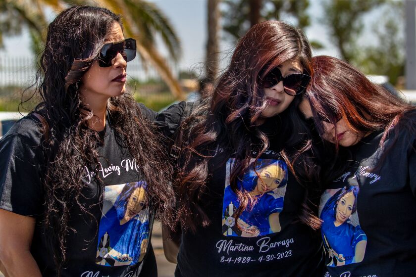LANCASTER, CA - MAY 13: Lizeth Gaxiola, left, Angela Sanchez, and Vanessa Sandoval grieve at a fundraiser car wash for their sister one of four Mojave shooting victim Martina Barraza held at Sammy's Restaurant, Lancaster, CA. (Irfan Khan / Los Angeles Times)