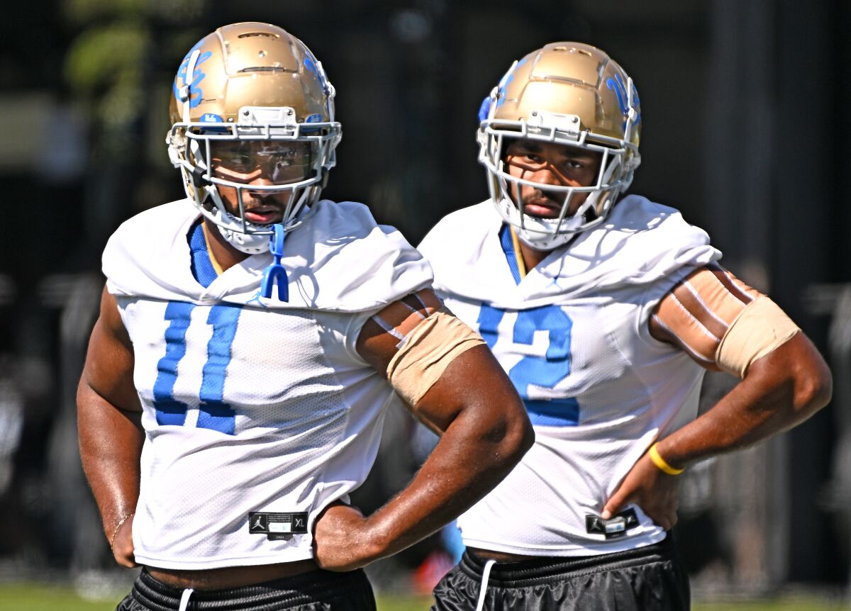 UCLA's Gabriel Murphy (11) and twin brother Grayson take a break during football practice.