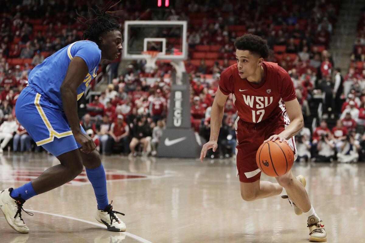 Washington State guard Isaiah Watts drives to the basket while pressured by UCLA guard Will McClendon 