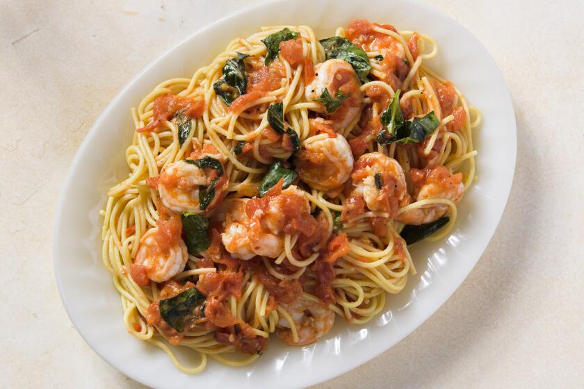 This image released by Milk Street shows a recipe for spaghetti with shrimp, tomatoes and white wine. (Milk Street via AP)