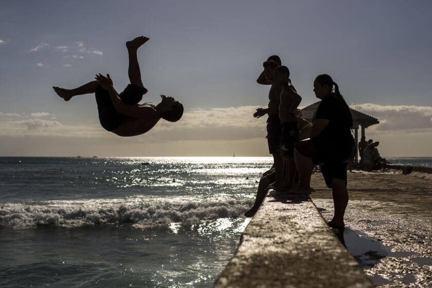 A young man launches off the Wall at Waikiki.