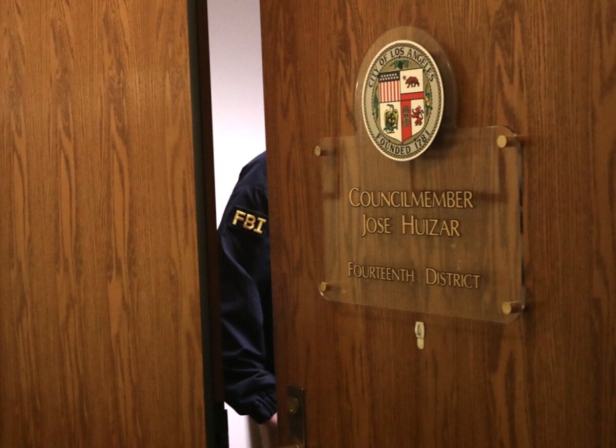 An FBI agent is seen in the doorway of former L.A. City Councilman Jose Huizar's City Hall office