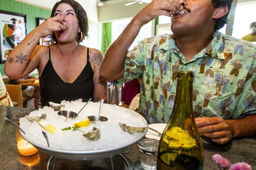 LOS OLIVOS, CA - SEPTEMBER 02, 2021:Linda Wenger and Eric Aispuro of Santa Barbara eat oysters while sitting at the bar inisde Bar Le Cote, a new seafood restaurant in Los Olivos. (Mel Melcon / Los Angeles Times)