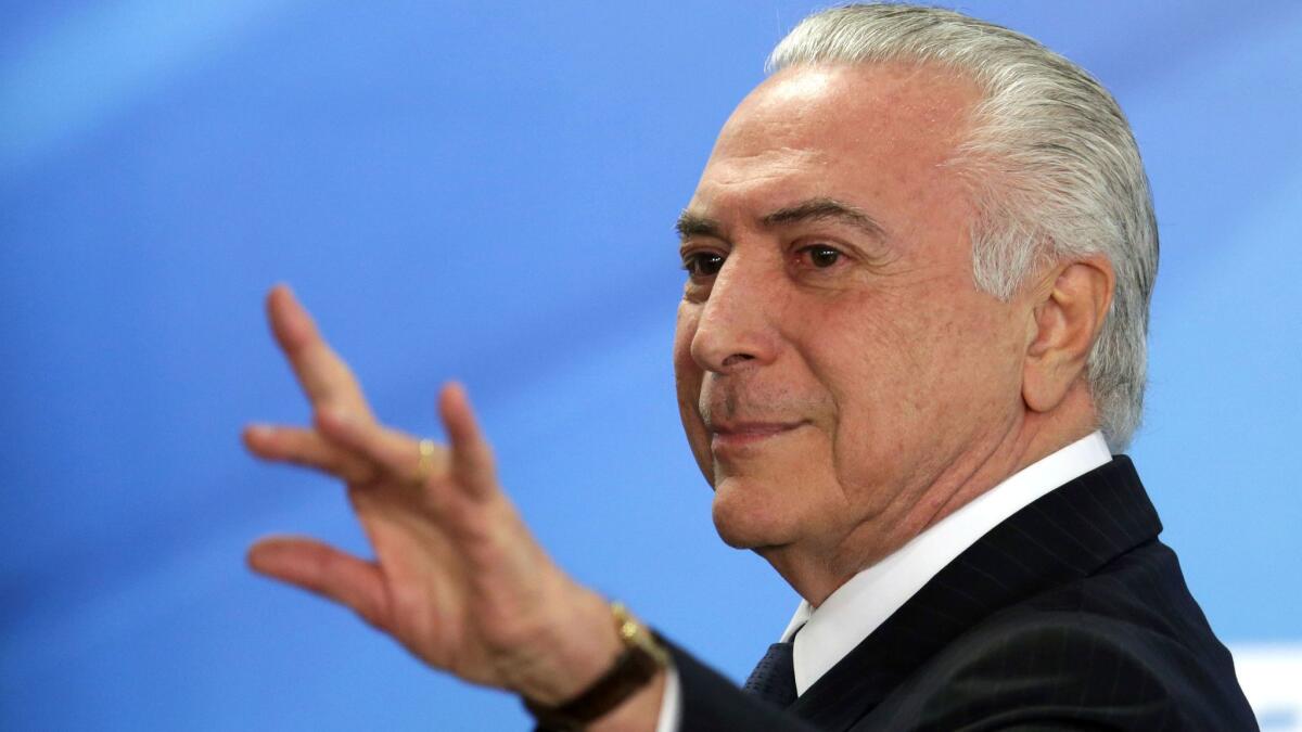 Brazilian President Michel Temer waves as he leaves a ceremony at the Planalto presidential palace in Brasilia on June 26, 2017.